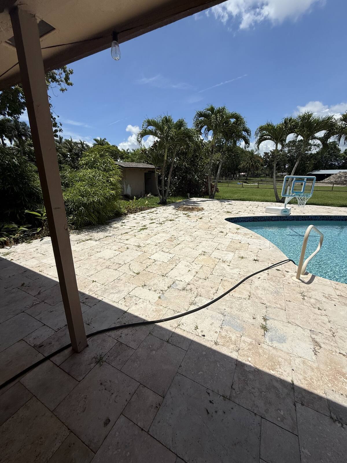 Clean travertine pool deck at a South Florida home