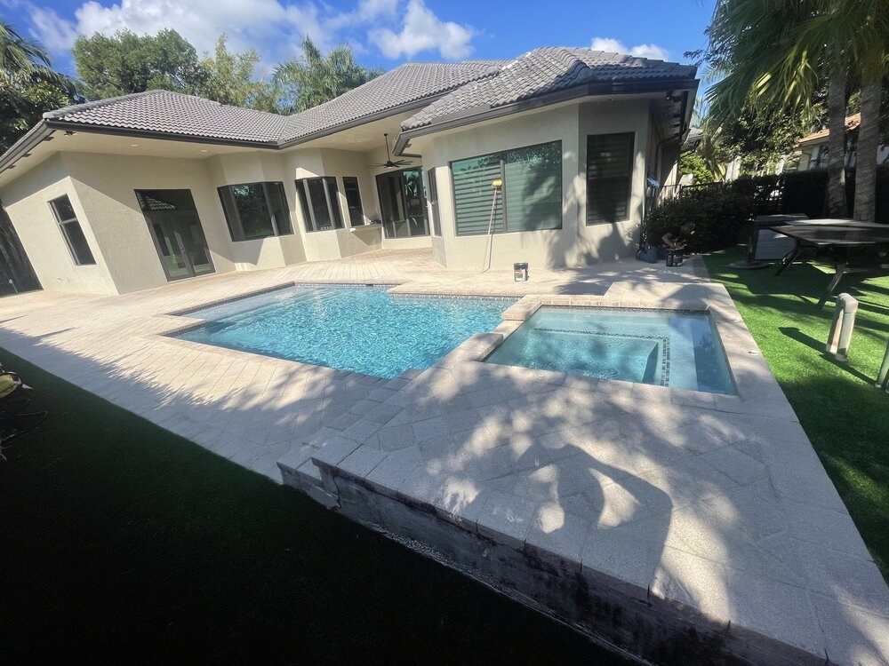 The same pool deck before sealing in South Florida — cleaned but unsealed, crew equipment still out