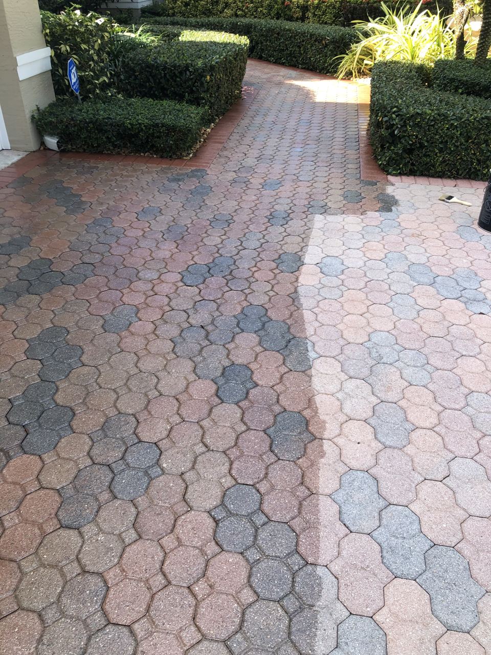 Paver surface mid-clean in South Florida — clean on one side, still dirty on the other