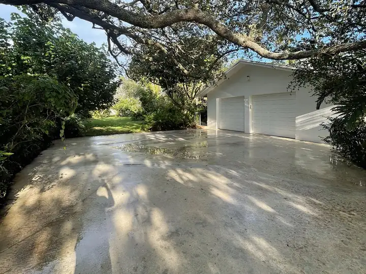 Shaded concrete driveway in South Florida after pressure washing — after