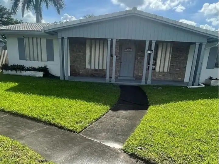 South Florida home exterior with a mildew-darkened walkway — before