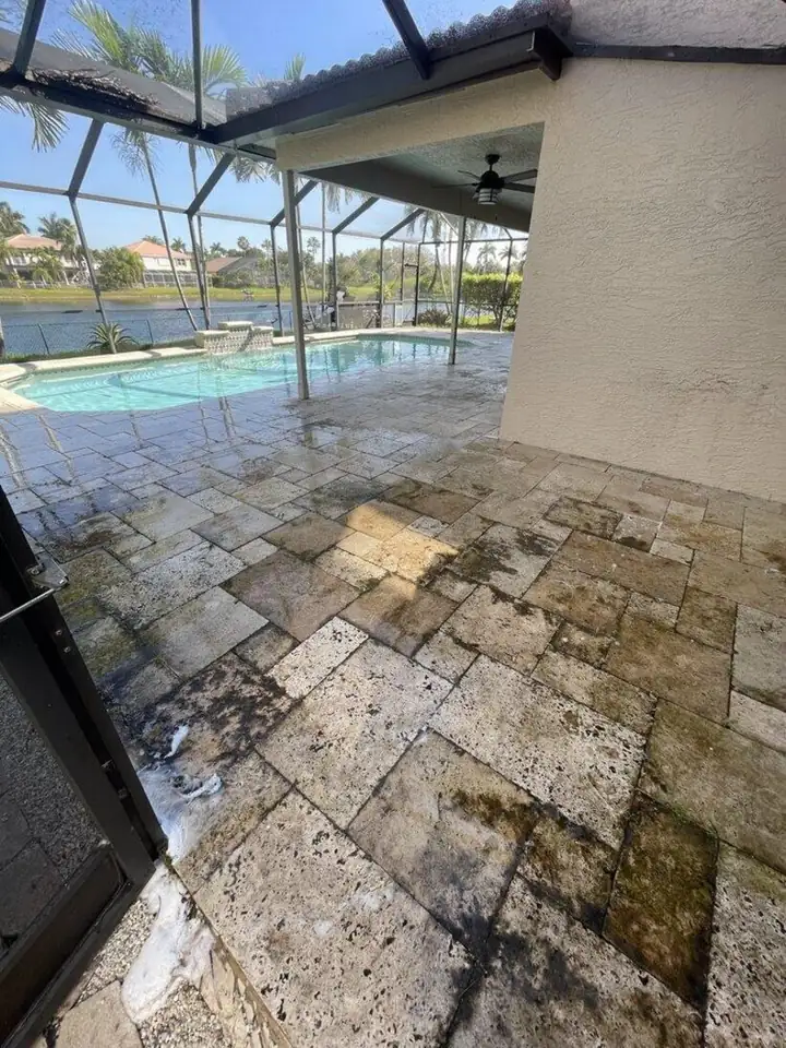 Dirty travertine pool deck before pressure cleaning in Weston, FL